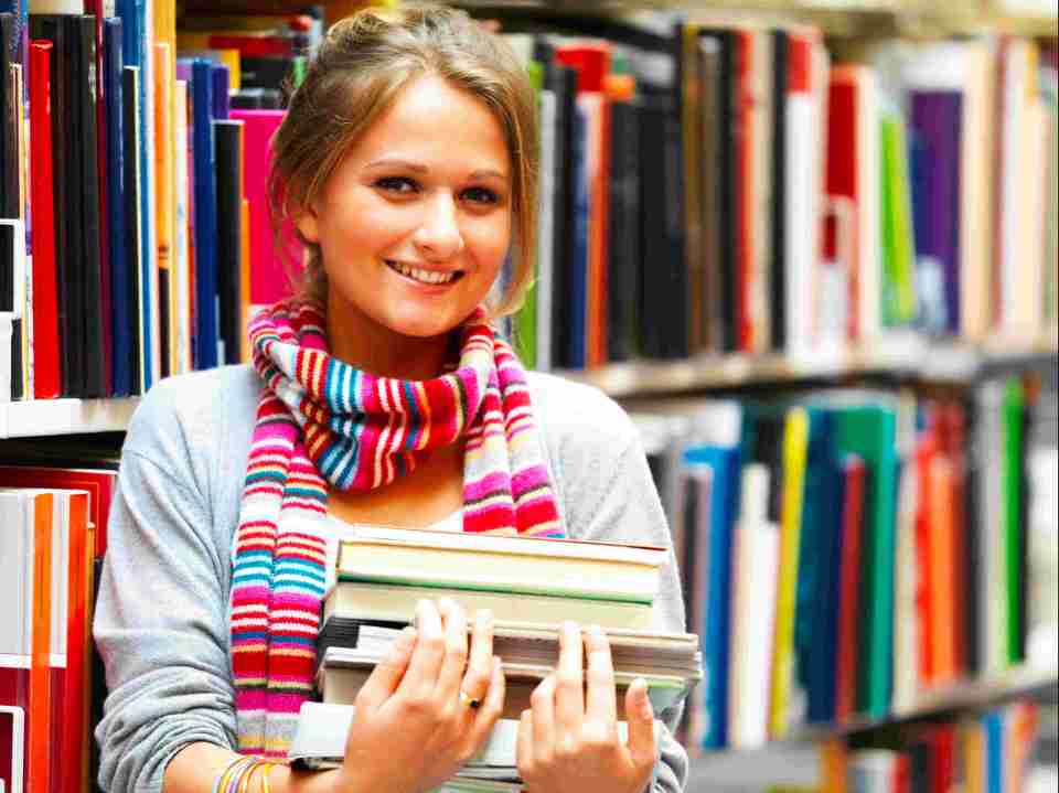 Pretty charming lady holding books in library